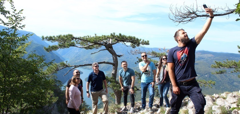 Group of travelers taking selfie with Drina river in the back